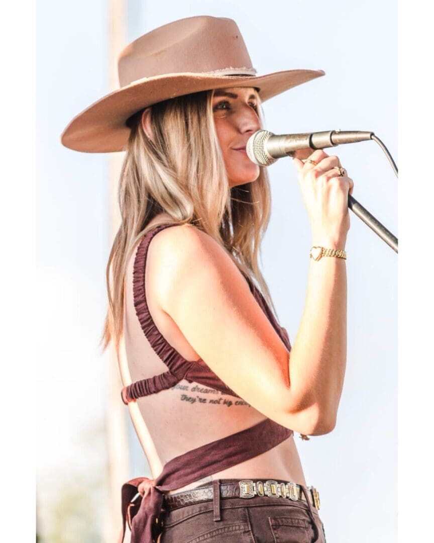 Female Singer in Brown Hat Singing into Microphone - Gas City Performing Arts Center Female singer in brown hat singing into microphone