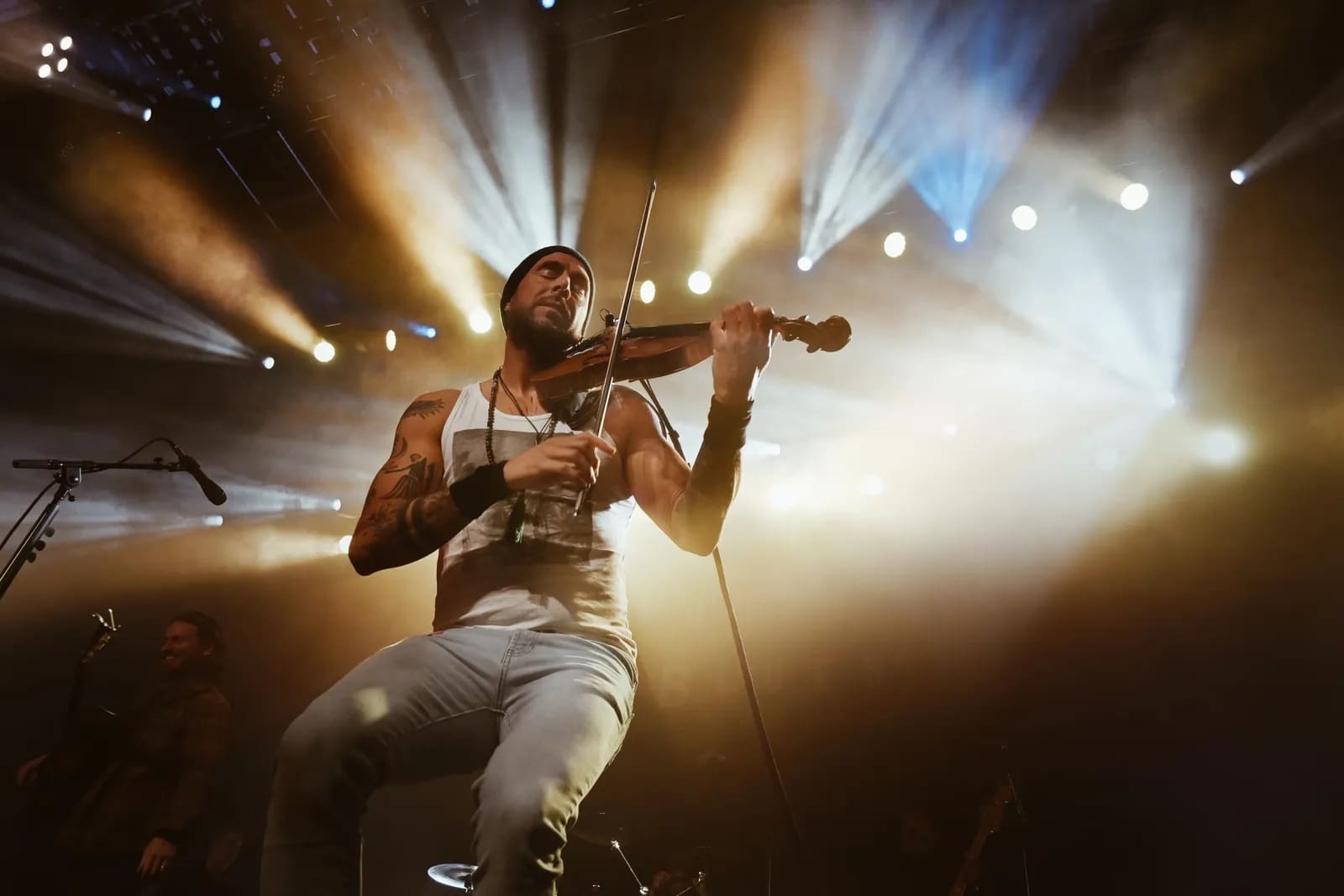 Violinist performing on stage under dramatic lights